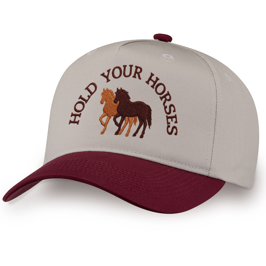 Burgundy embroidered snapback hat with Hold Your Horses stitched across the front