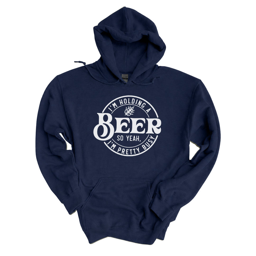 Navy hoodie printed with the Im Holding A Beer design across the front
