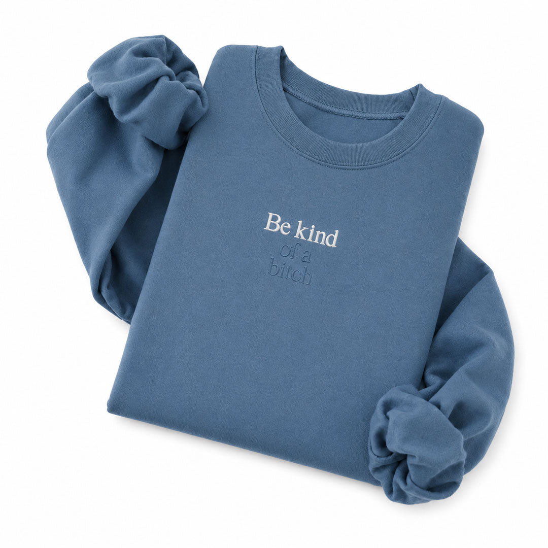 Indigo Blue crewneck sweatshirt embroidered with Be kind in white thread and of a bitch in tonal thread below