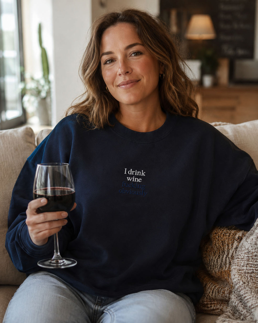 Close-up of I drink wine fucking obviously embroidery on a Properly Improper crewneck sweatshirt