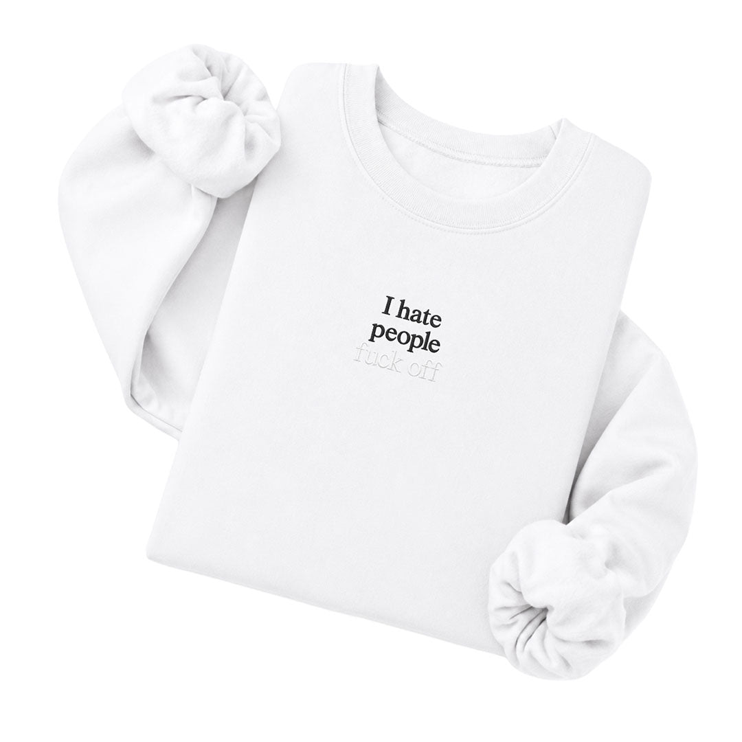 White crewneck sweatshirt embroidered with I hate people in black thread and fuck off in tonal thread below