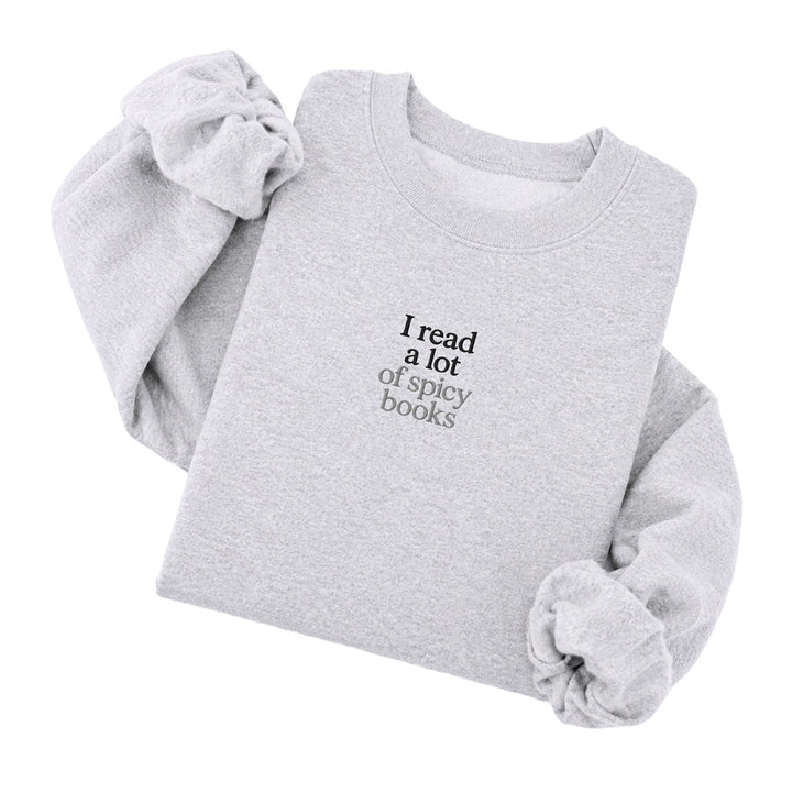 Ash crewneck sweatshirt embroidered with I read a lot in black thread and of spicy books in tonal thread below