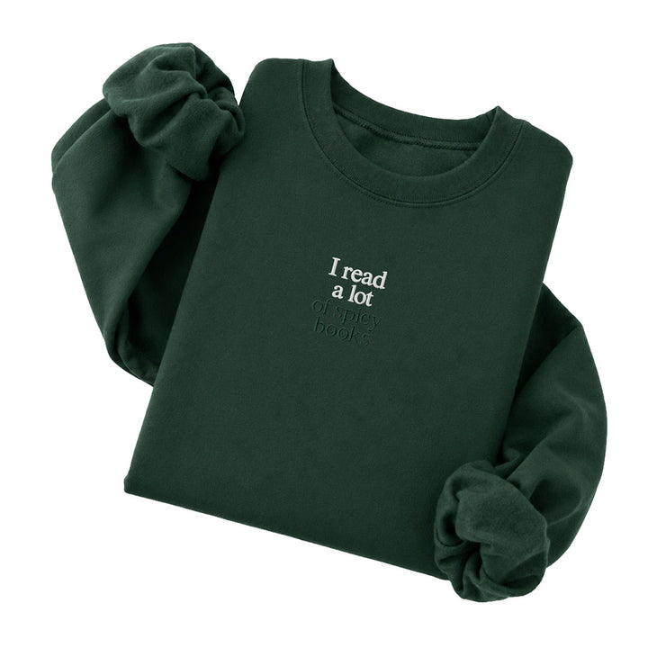 Forest Green crewneck sweatshirt embroidered with I read a lot in white thread and of spicy books in tonal thread below