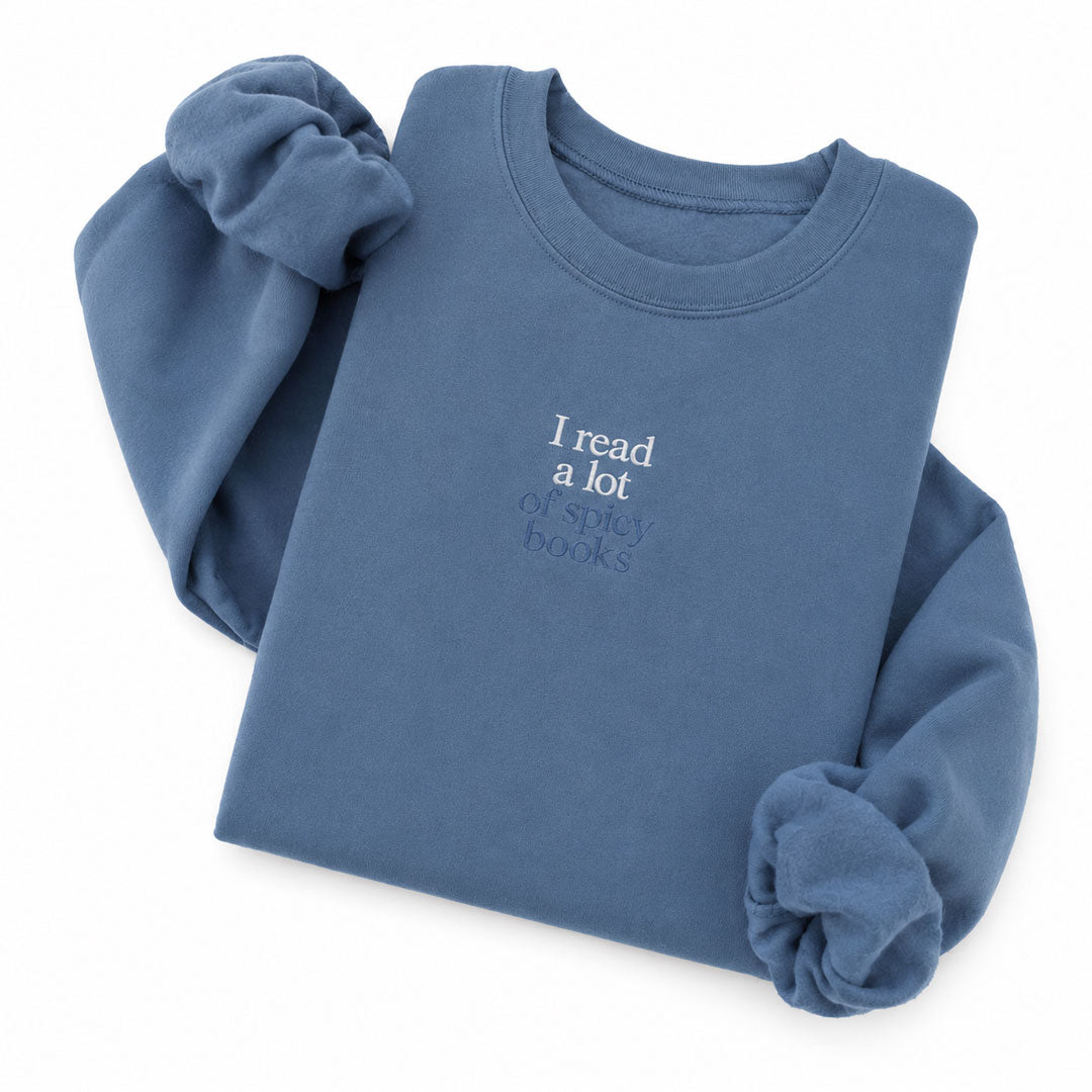 Indigo Blue crewneck sweatshirt embroidered with I read a lot in white thread and of spicy books in tonal thread below