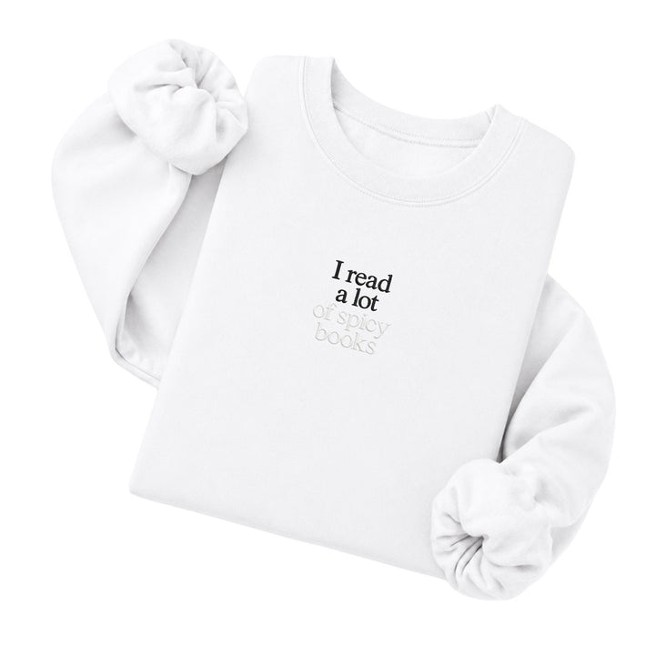 White crewneck sweatshirt embroidered with I read a lot in black thread and of spicy books in tonal thread below