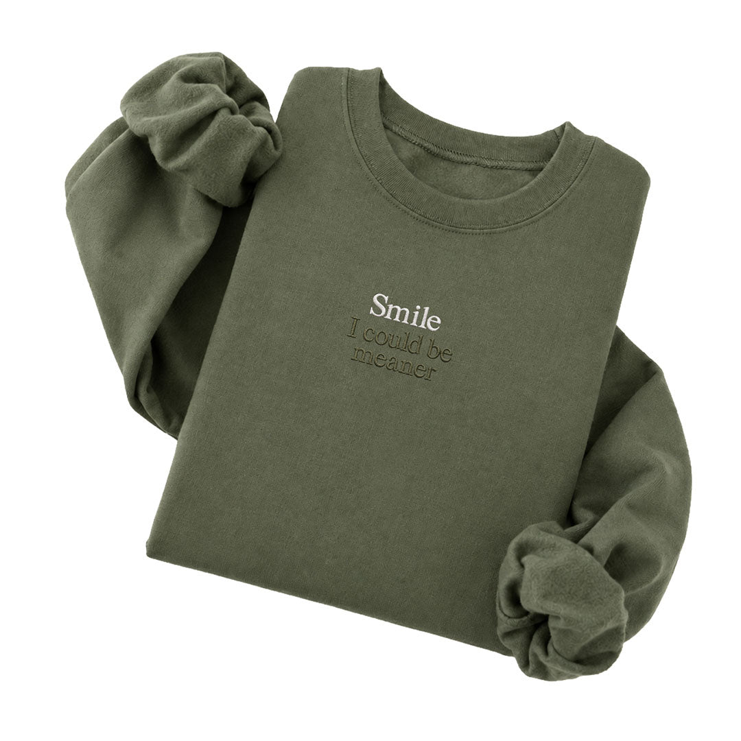 Military Green crewneck sweatshirt embroidered with Smile in white thread and I could be meaner in tonal thread below