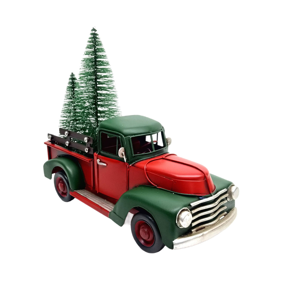 Vintage-style red metal pickup truck with green evergreens in the bed