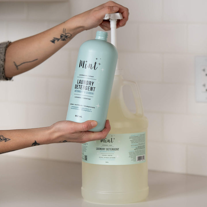 Person refilling a Mint Laundry Detergent bottle from the 3.8L refill jug